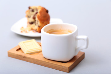 Classic espresso in white cup with cake and chocolate on white background.