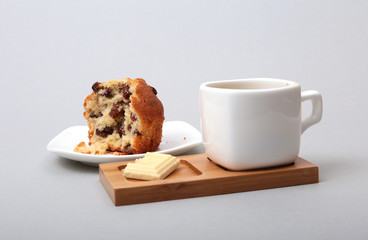 Classic espresso in white cup with cake and chocolate on white background.