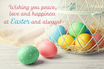 Basket with colourful Easter eggs on wooden table