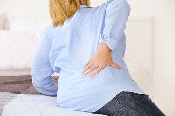 Senior woman suffering from backache at home, closeup