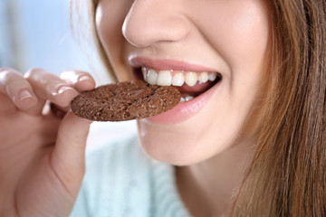 Young woman eating cookie, closeup