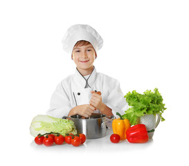 Cute boy in chef uniform preparing tasty soup, on white background