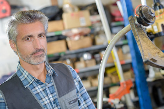 Portrait of mechanic in front of strimmer