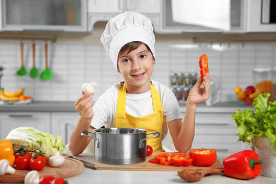 Cute boy cooking in kitchen at home