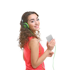 Happy young woman in headphones listening to music on white background