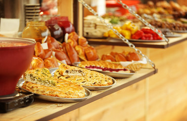 Trays with different kinds of pies on counter