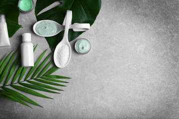 Natural cosmetics and leaves on grey background