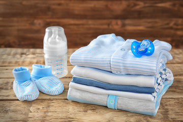 Pile of baby clothes on wooden background