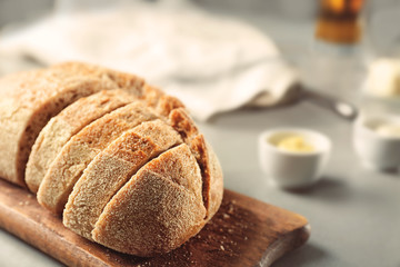 Wooden cutting board with sliced loaf of beer bread on table