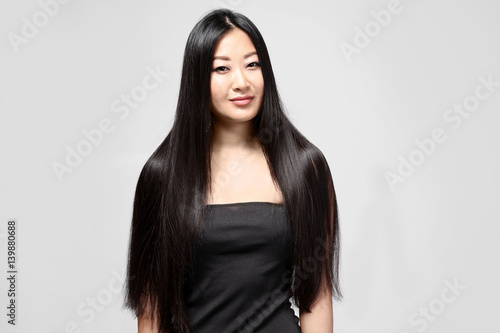 Beautiful Asian Woman With Long Straight Hair On Light Background