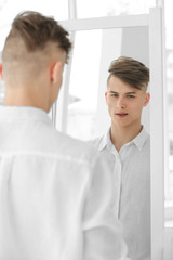 Fototapeta premium Handsome young man looking at mirror