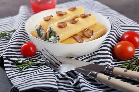 Delicious stuffed cannelloni with mushrooms on plate