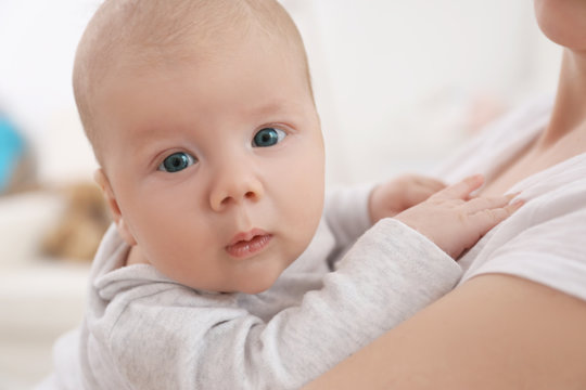 Young woman with cute little baby at home, closeup