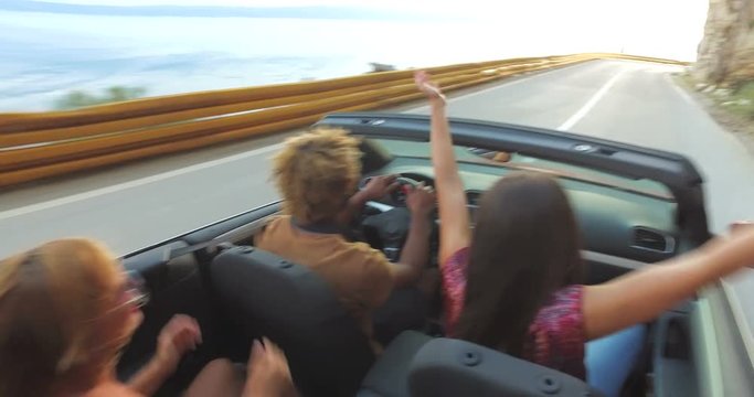 Black man with dreadlocks partying with friends while driving in convertible