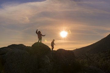 Girls playing at sunset on top of the mountain