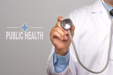 Doctor holding a stethoscope and word "PUBLIC HEALTH" on gray background. concept Healthy.