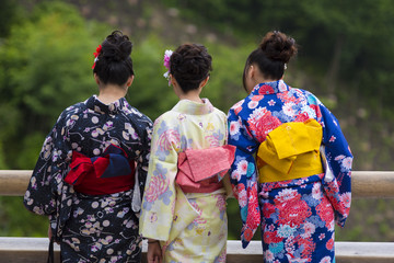 Naklejka premium KYOTO, JAPAN - NOVEMBER 25 2015: Women tourism wear a traditional dress called Kimono for travelling in Kyoto on November 25 2015.
