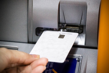 hand insert debit card into bank machine