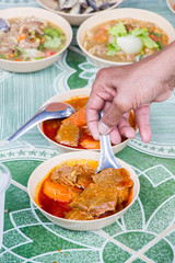  man scoop beef curry in the bowl