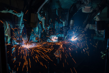 Team robots are welding in factory