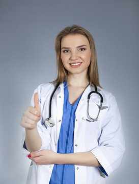 Young  attractive woman doctor holds   finger up and smile. 