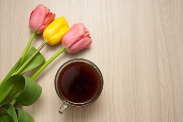 black coffee and tulips on the table, top view, empty copyspace.