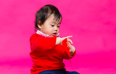 Little boy holding a red pocket
