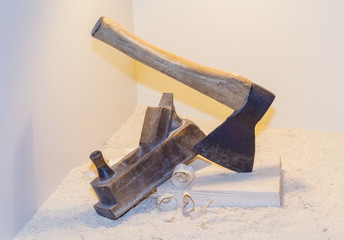 Old ax, planer and shavings on a light background.