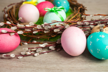 Easter composition of the branches, cakes, tulips colored eggs cooked for the holiday on the wooden background