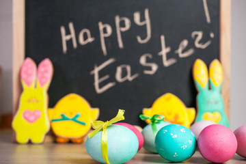 Easter composition of colored eggs, the Easter Bunny and the inscription "Happy Easter"