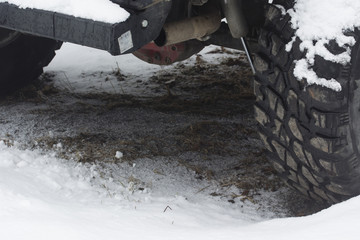The exhaust pipe and universal joint at the car parts with snow tires.