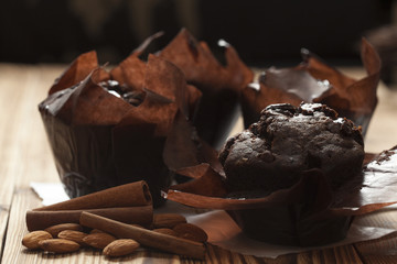 chocolate muffins on wooden background wrapped in paper