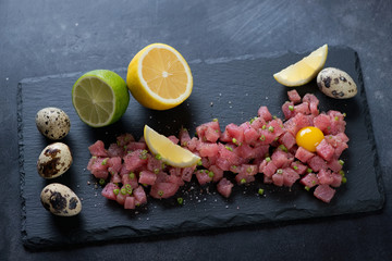 Tuna tartar served on a stone slate tray, studio shot, selective focus