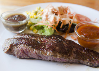 grilled ostrich steak with spicy turkey sauce, styled with onion and mushroom.
