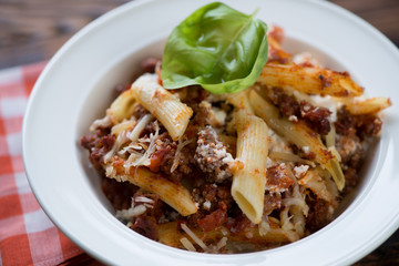 White glass plate with italian ziti casserole, close-up, studio shot