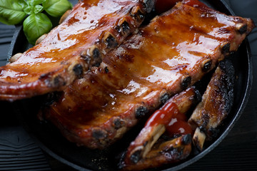 Close-up of baked pork ribs glazed in honey and soy sauce, selective focus