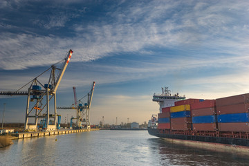 Szczecin ,Poland-January 2017:sea container flows into port for unloading harbor cranes and gantries