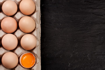 eggs in a tray on a dark background with copy space for your text. Top view