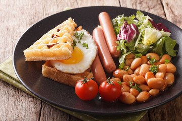 Healthy breakfast: waffle sandwich with egg, sausages, beans and salad close-up. horizontal