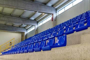 Fototapeta premium rows of blue chairs on the podium of the sports hall