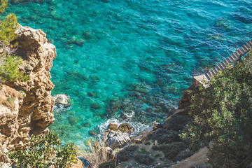 Stairs over rock and way down to lagoon and turquoise sea waters at South Mediterranean coast of Turkey near Koru beach in Gazipasa town