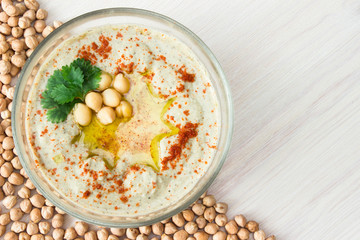 A bowl of creamy hummus with olive oil.