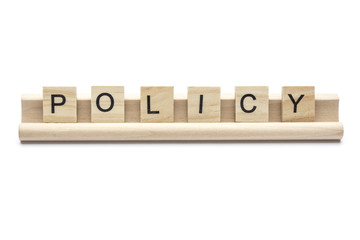 Word ''policy'' on scrabble wooden letters on a rack, isolated on white background