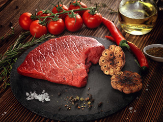 Raw beef steak on a stone plate.