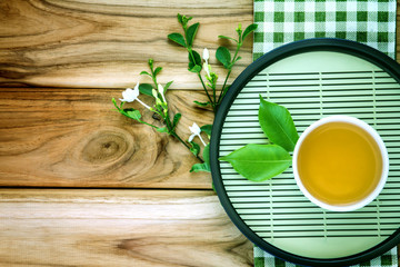 Top view or overhead shot of a cup of tea decoration on wooden background ,Japanese organic tea style concept.