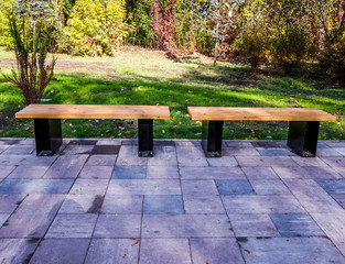 bench in sunny park with grey stones and green grass
