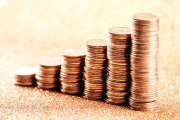 Stacks of copper coins on golden background