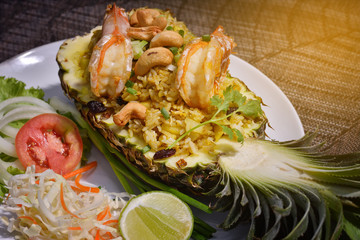 Baked rice with pineapple served in a pineapple , light effect.