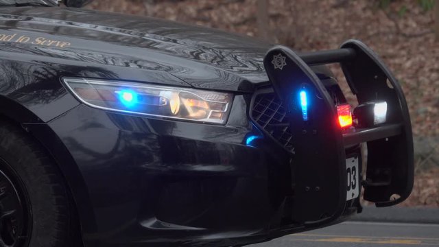 Cars driving by front end of police car