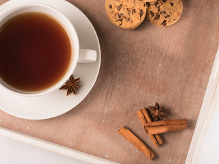 White cup of tea on the tray with cookie and chicory